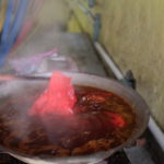 In einem heißen Wok voll mit leckerer Farbe und flüssigem Wachs.