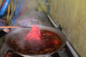 In einem heißen Wok voll mit leckerer Farbe und flüssigem Wachs.